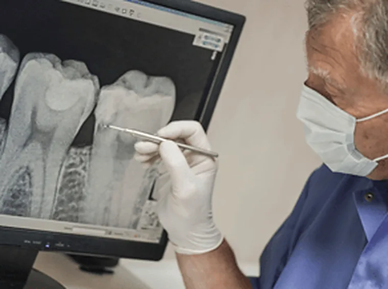 A dentist reading radiographs, which is how implant positions are planned.
