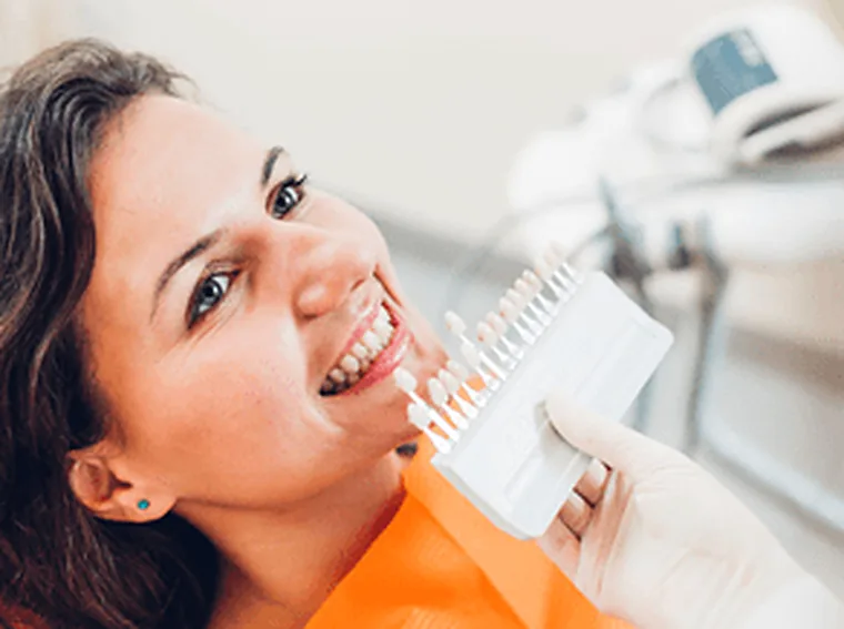 A shade guide held against a patient&rsquo;s teeth to match a restoration.